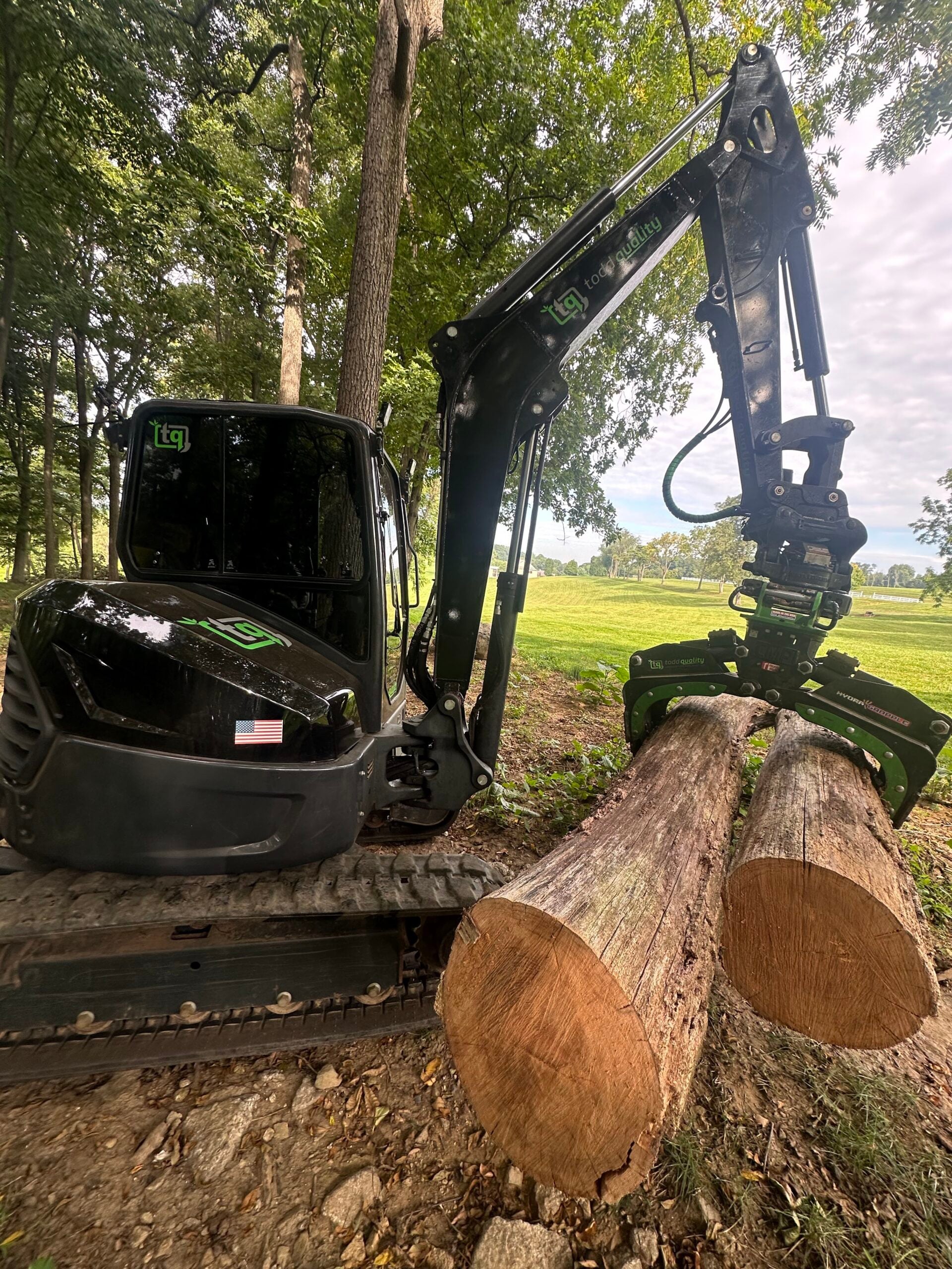Todd Quality excavator handling cut hardwood logs